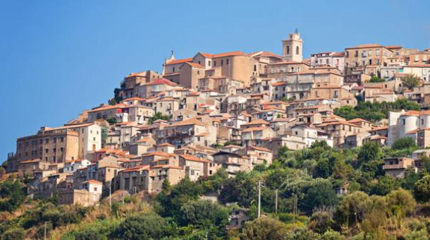 A picturesque hilltop village with stone houses and a central church.