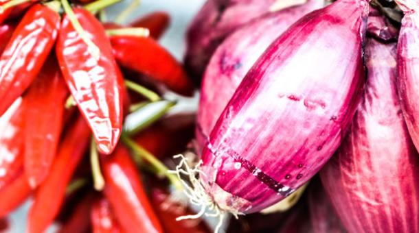 Red onions and fresh chili peppers in close-up.