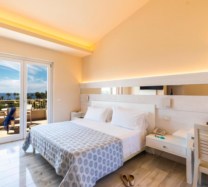 Chambre lumineuse avec lit double, TV, balcon vue mer.