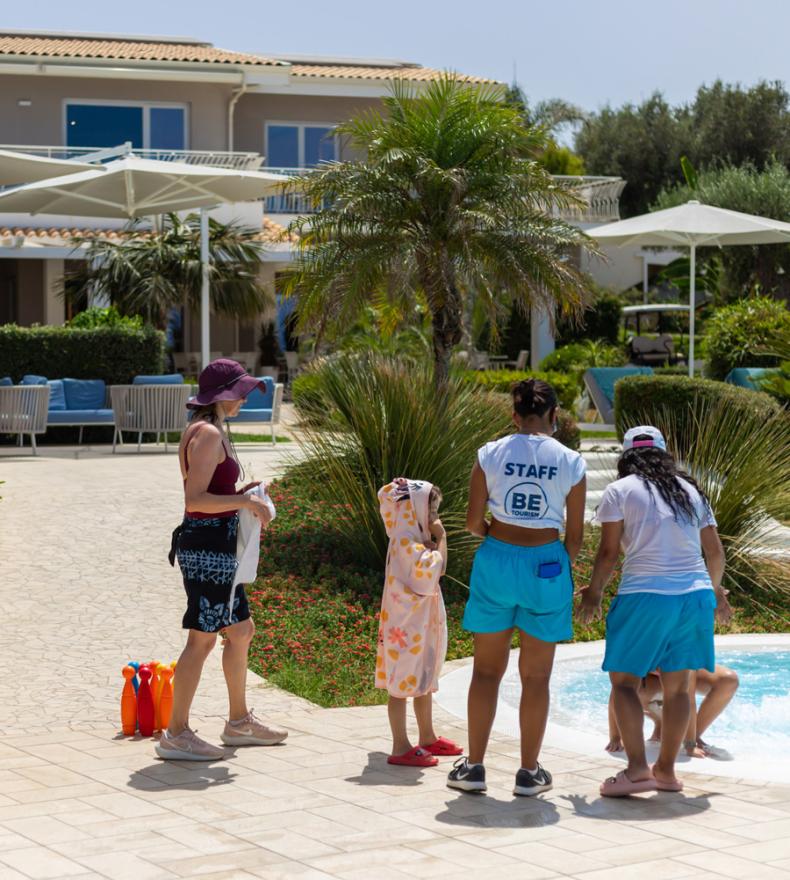 Famiglia e staff vicino alla piscina di un resort.