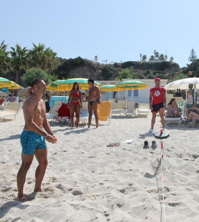 People playing beach tennis on a sunny beach.